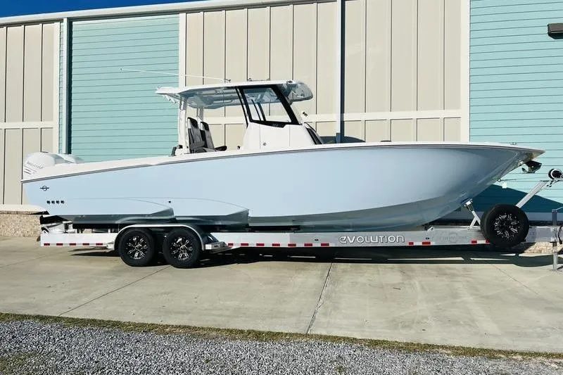  Yacht Photos Pics 2023 Fountain 32 NX boat on trailer, parked outdoors near a building.