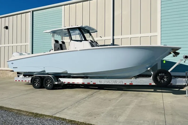  Yacht Photos Pics 2023 Fountain 32 NX boat on trailer, parked outside a building.