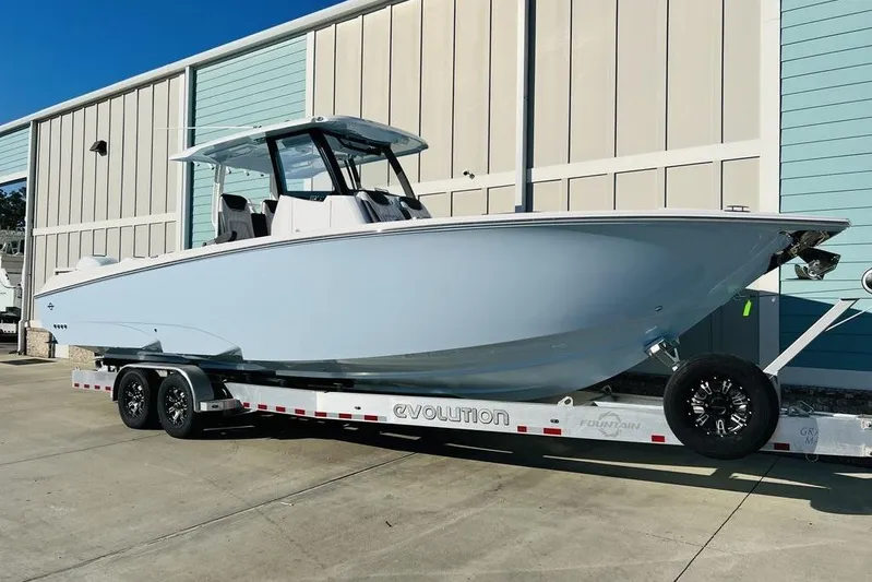  Yacht Photos Pics 2023 Fountain 32 NX boat on trailer, parked outside a building.