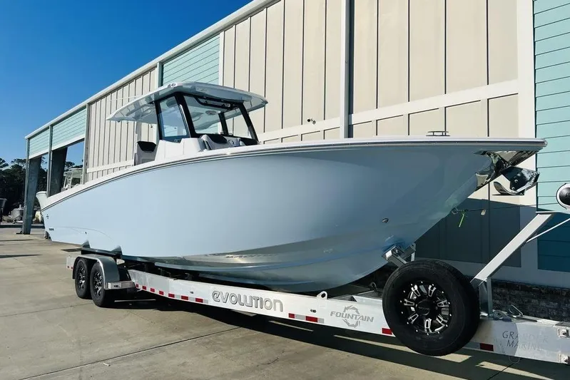  Yacht Photos Pics 2023 Fountain 32 NX boat on trailer, parked outside a building.