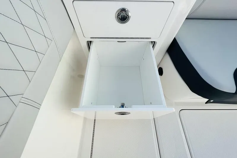  Yacht Photos Pics Open storage compartment on 2023 Fountain 32 NX boat, featuring sleek white interior design.