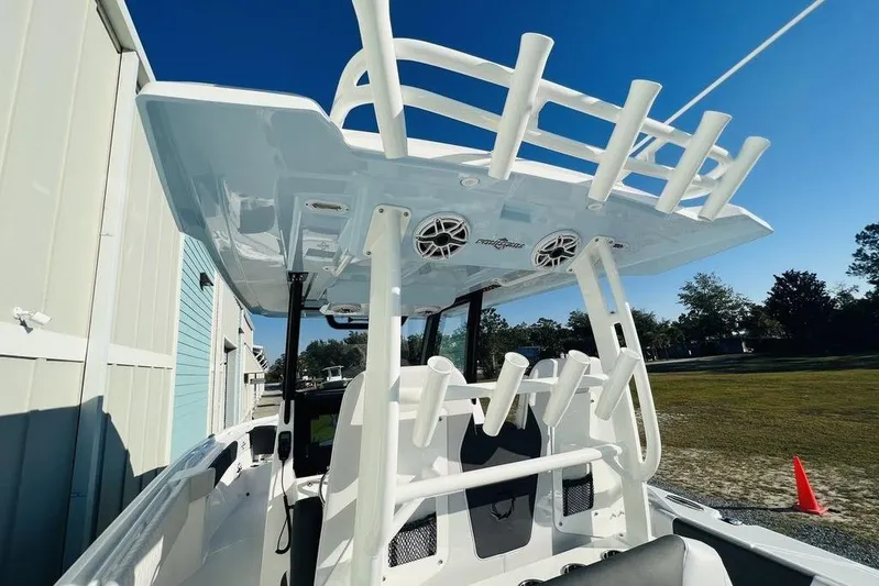  Yacht Photos Pics 2023 Fountain 32 NX boat with rod holders and speakers, docked outdoors under clear sky.