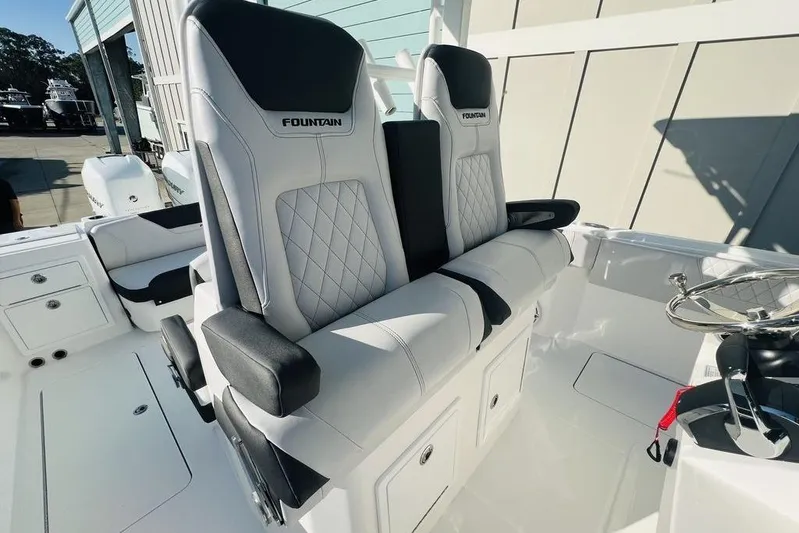  Yacht Photos Pics 2023 Fountain 32 NX boat interior with luxurious seating and modern steering wheel.