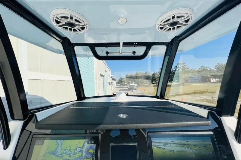  Yacht Photos Pics 2023 Fountain 32 NX boat cockpit with navigation screens and overhead speakers.