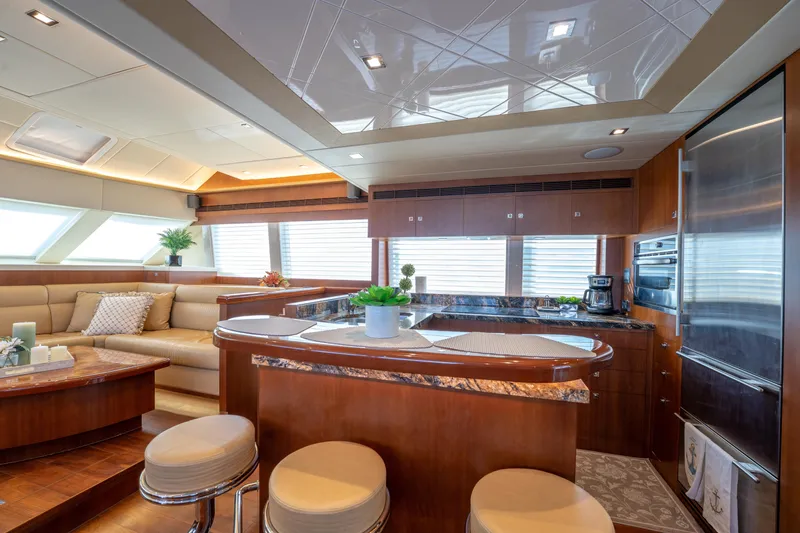 Island Girl Yacht Photos Pics Luxurious interior of 2016 Horizon PC52 yacht with modern kitchen and seating area.