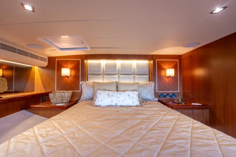 Island Girl Yacht Photos Pics Luxurious cabin interior of 2016 Horizon PC52 yacht with elegant bedding and warm lighting.