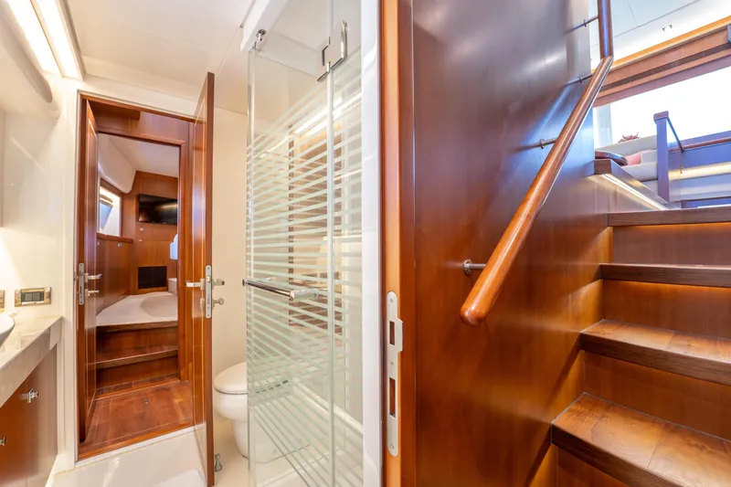 Island Girl Yacht Photos Pics Luxurious interior of 2016 Horizon PC52 yacht with wooden stairs and modern bathroom.
