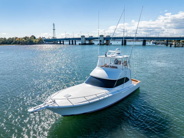 Amore Mia Yacht Photos Pics 2015 Viking 46 Convertible yacht on calm water near a bridge under a clear sky.