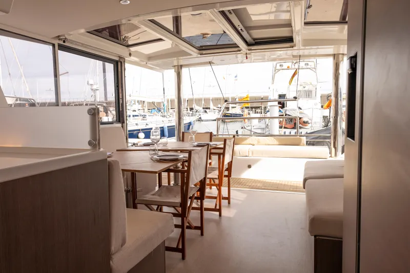 Tatani Yacht Photos Pics Luxurious interior of 2021 Bali 4.8 yacht with dining area and marina view.