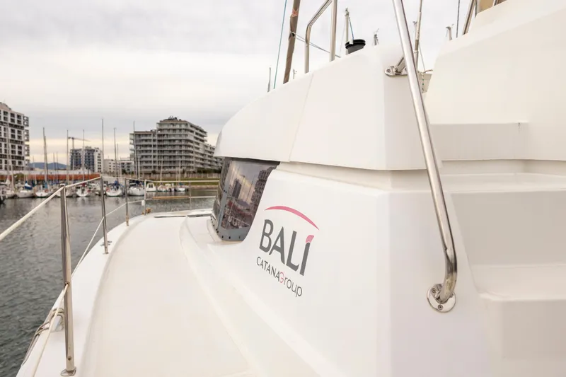 Tatani Yacht Photos Pics Bali 4.8 catamaran docked in marina, 2021 model, with cityscape background.