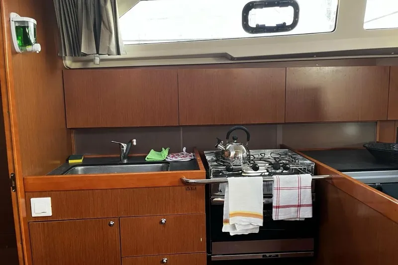  Yacht Photos Pics Galley kitchen in 2017 Beneteau Oceanis 41.1 yacht with stove, sink, and kettle.