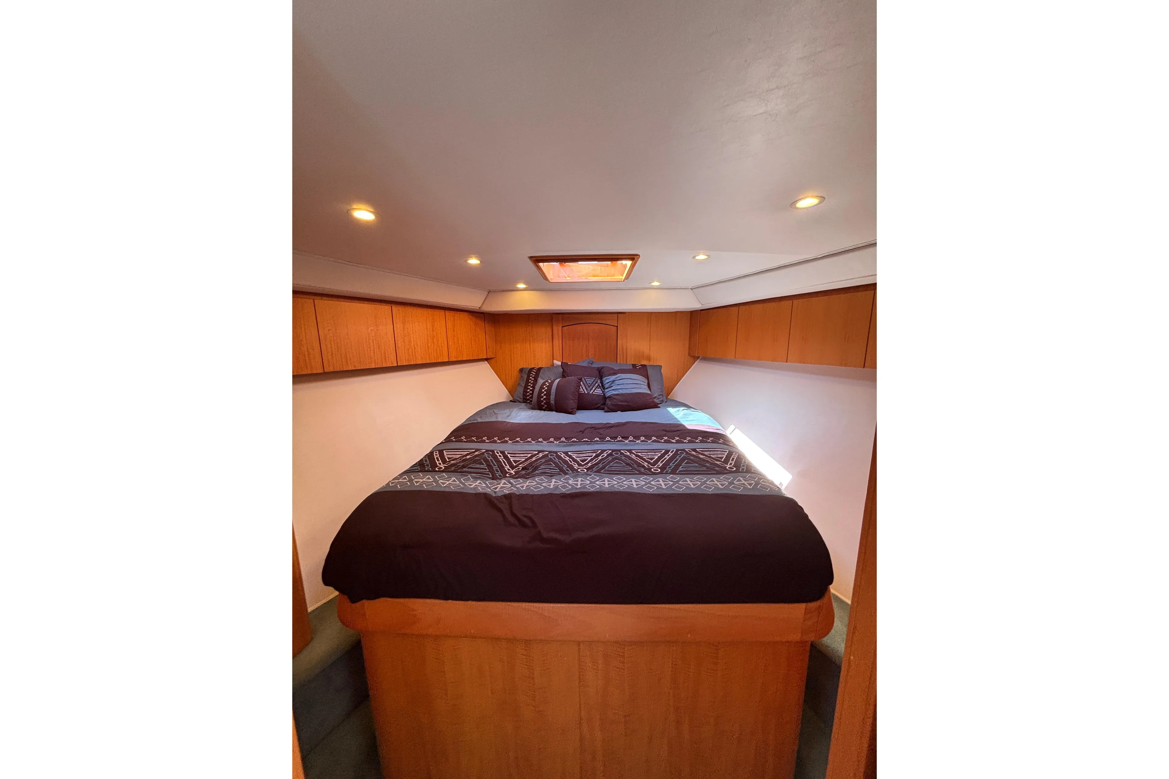 Luxurious cabin interior of 2006 Dixon 52 yacht with cozy bedding and wooden accents.