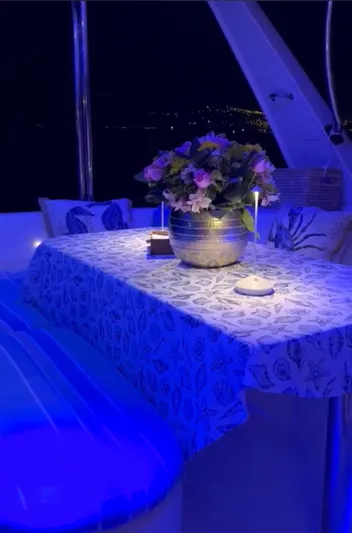 Una Vida Yacht Photos Pics Luxurious Leopard 47 yacht interior with floral centerpiece, ambient blue lighting, and elegant decor.