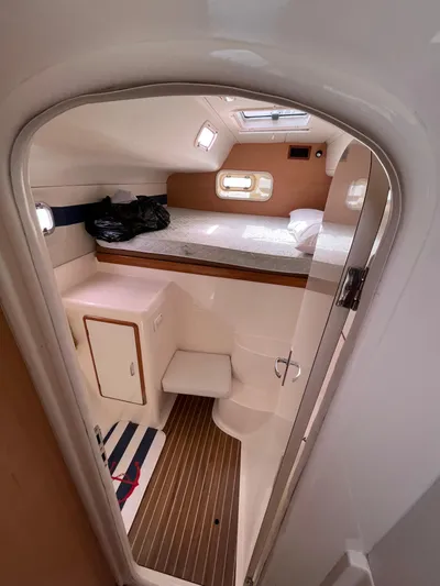 Una Vida Yacht Photos Pics Interior of 2004 Leopard 47 yacht cabin with bed, storage, and wooden flooring.
