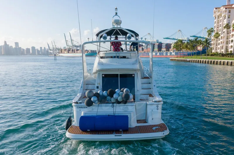  Yacht Photos Pics 2004 Carver 420 Mariner yacht cruising near a port with city skyline in the background.