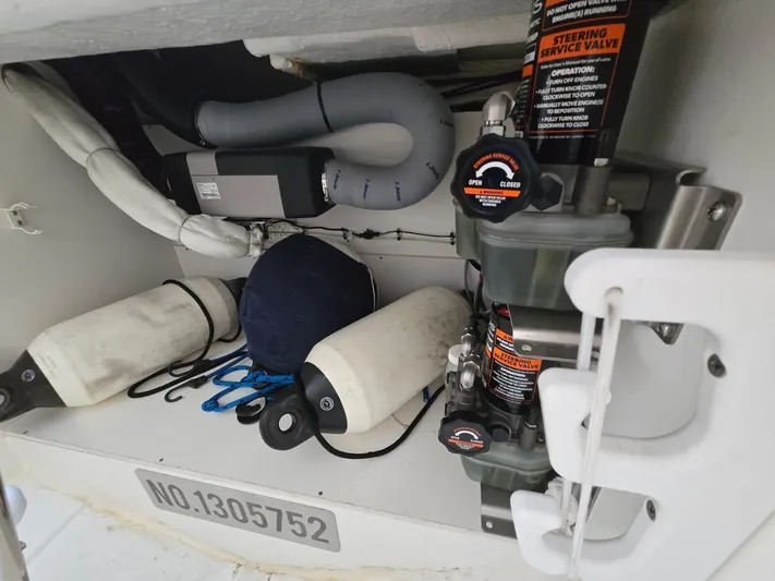 Down Time Yacht Photos Pics Storage compartment of 2020 Jeanneau NC 895 Sport with marine equipment and steering service valve.