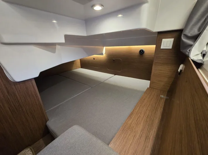 Down Time Yacht Photos Pics 2020 Jeanneau NC 895 Sport cabin interior with modern wood finish and cozy sleeping area.