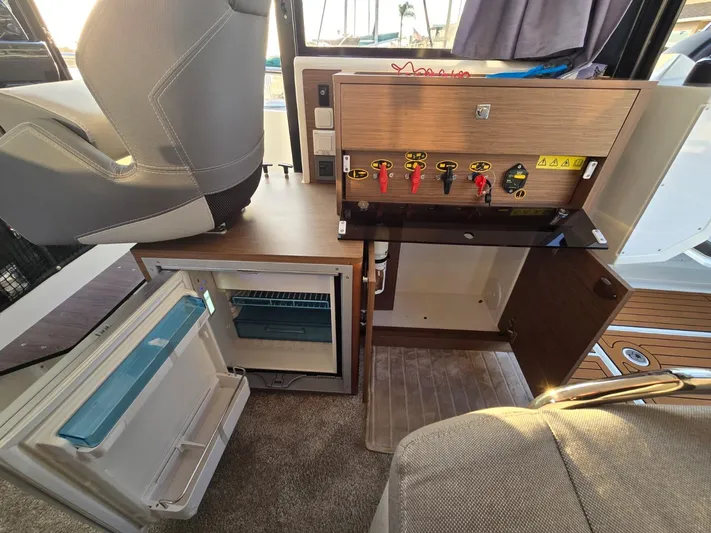 Down Time Yacht Photos Pics 2020 Jeanneau NC 895 Sport interior with control panel and open mini fridge.