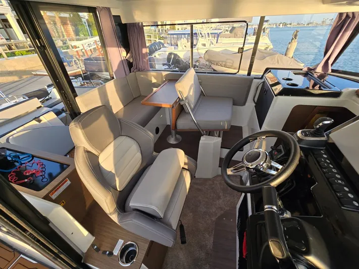 Down Time Yacht Photos Pics Interior of 2020 Jeanneau NC 895 Sport boat with seating and steering area.