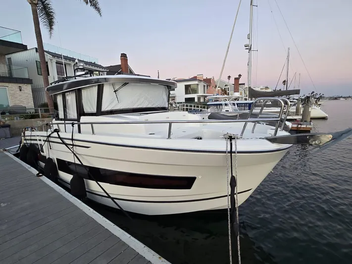 Down Time Yacht Photos Pics 2020 Jeanneau NC 895 Sport boat docked at a marina, showcasing sleek design and modern features.