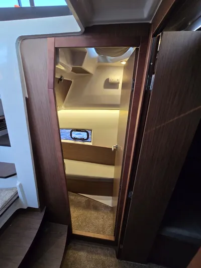 Down Time Yacht Photos Pics 2020 Jeanneau NC 895 Sport cabin interior with wooden finishes and window.