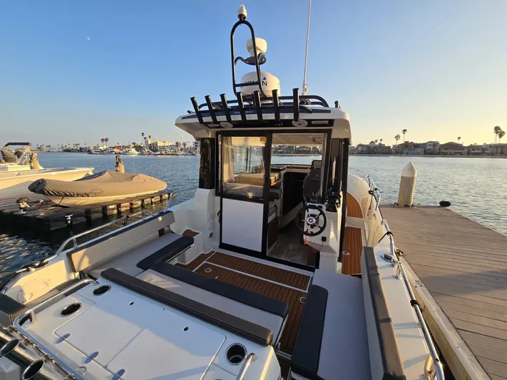 Down Time Yacht Photos Pics 2020 Jeanneau NC 895 Sport boat docked at marina during sunset.