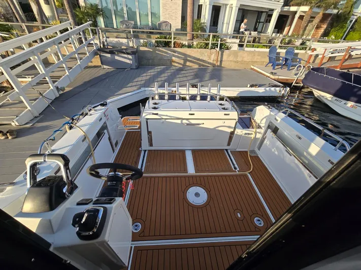 Down Time Yacht Photos Pics 2020 Jeanneau NC 895 Sport boat interior with teak flooring and modern helm.