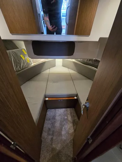 Down Time Yacht Photos Pics 2020 Jeanneau NC 895 Sport cabin interior with cozy sleeping area and wooden finishes.