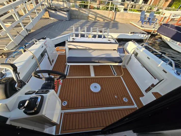 Down Time Yacht Photos Pics 2020 Jeanneau NC 895 Sport boat interior with teak flooring and seating area.