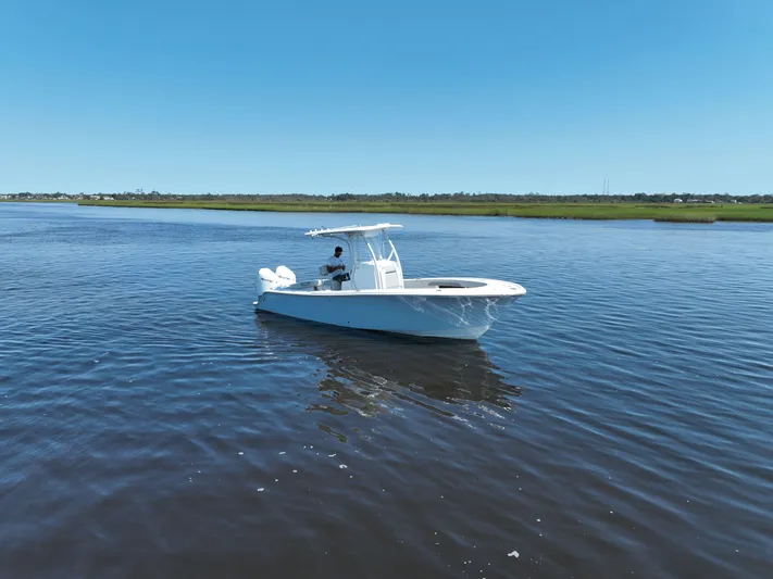 Motivated Yacht Photos Pics 2023 Front Runner 26 Center Console boat on calm water under clear blue sky.