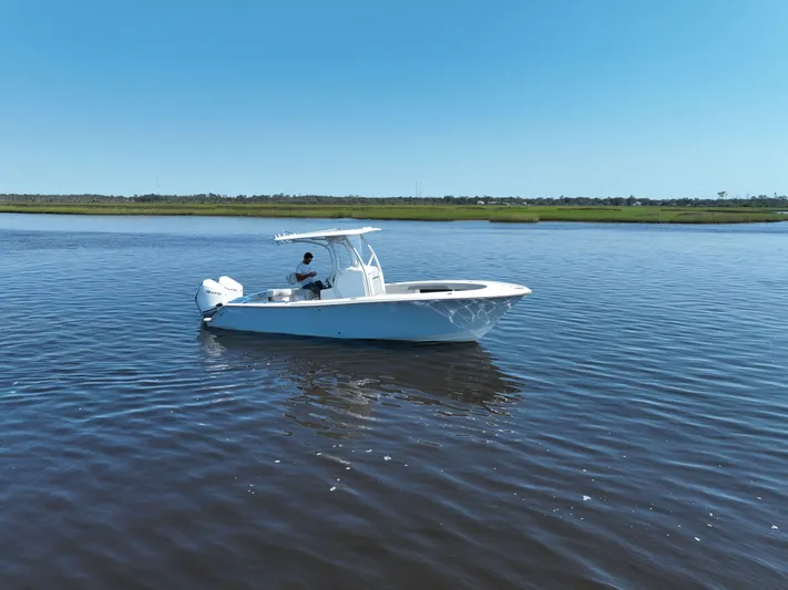 Motivated Yacht Photos Pics 2023 Front Runner 26 Center Console boat on calm water under clear blue sky.