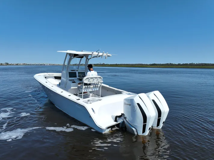 Motivated Yacht Photos Pics 2023 Front Runner 26 Center Console boat on calm water, featuring dual engines.