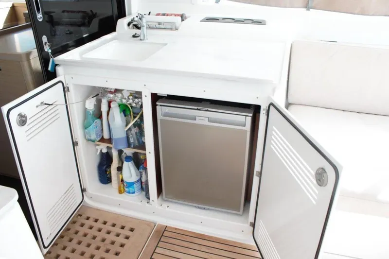 Jungle Goddess Yacht Photos Pics 2022 Lagoon 46 yacht kitchenette with sink, storage, and mini fridge.