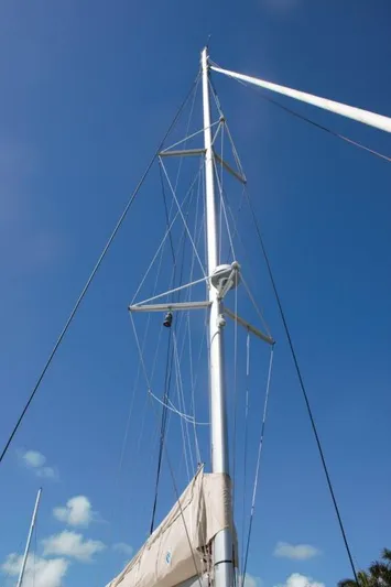 Jungle Goddess Yacht Photos Pics Mast of 2022 Lagoon 46 sailboat against clear blue sky.