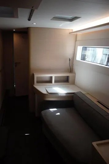 Jungle Goddess Yacht Photos Pics Interior of 2022 Lagoon 46 yacht, featuring a modern seating area and desk with natural light.