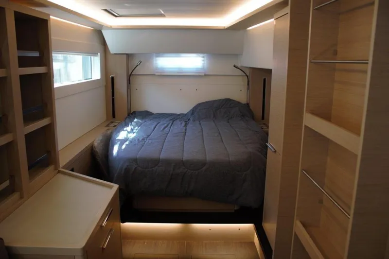 Jungle Goddess Yacht Photos Pics Modern bedroom interior of 2022 Lagoon 46 yacht with cozy bed and ambient lighting.