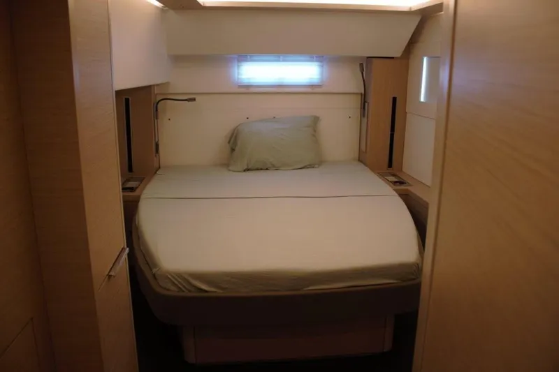 Jungle Goddess Yacht Photos Pics Cozy bedroom interior of 2022 Lagoon 46 yacht with modern design and soft lighting.