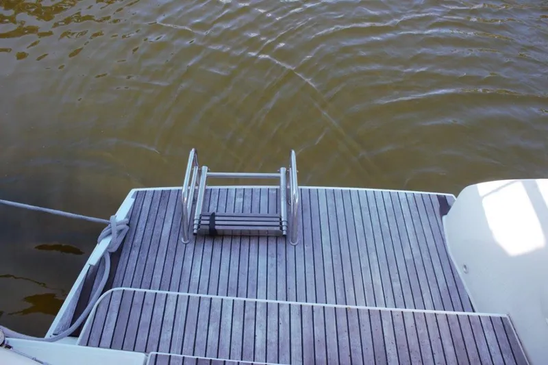 Jungle Goddess Yacht Photos Pics Stern view of 2022 Lagoon 46 catamaran with swim ladder and teak deck.