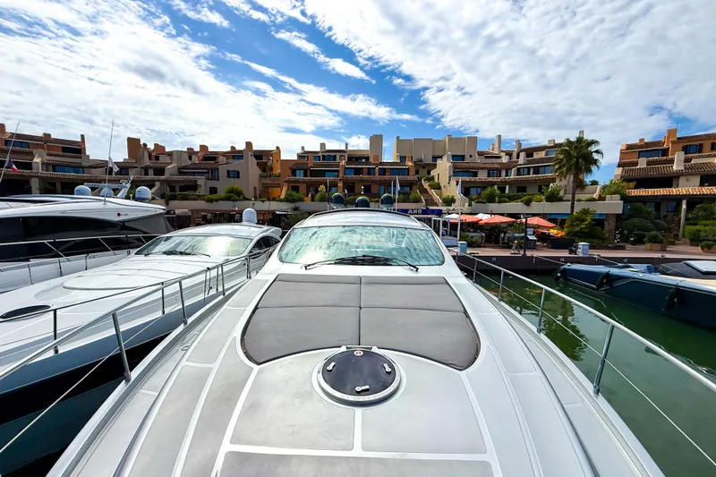  Yacht Photos Pics 2006 Pershing 56 yacht docked at a marina with modern buildings in the background.