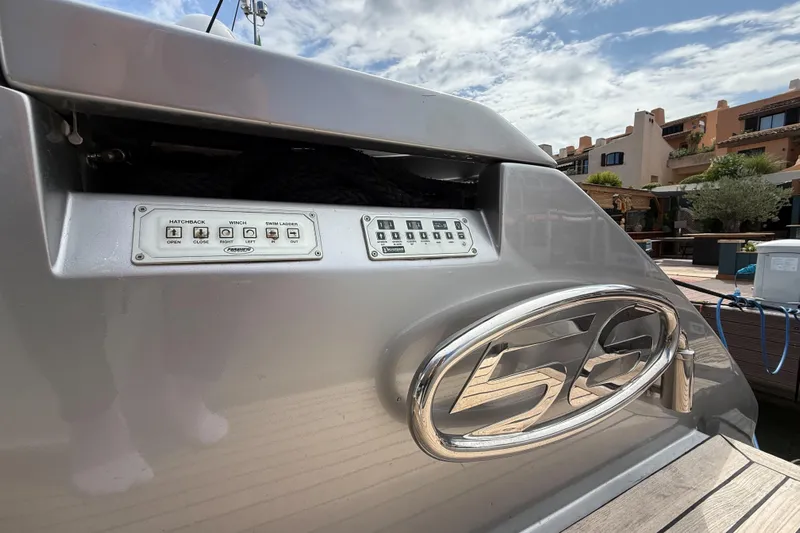  Yacht Photos Pics 2006 Pershing 56 yacht controls and emblem, docked under a partly cloudy sky.