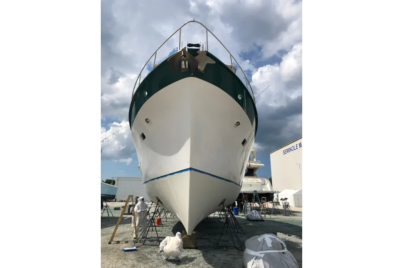 Noelani Yacht Photos Pics 1982 DeFever 52 Offshore Cruiser in shipyard, undergoing maintenance under cloudy sky.
