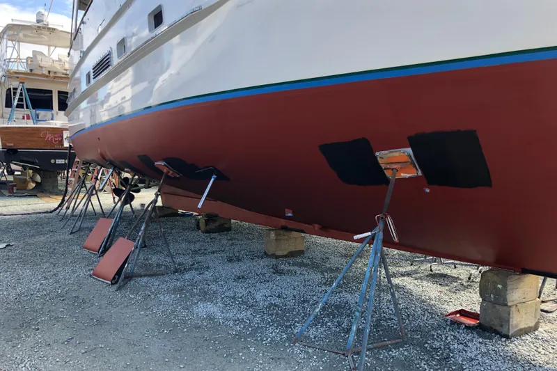 Noelani Yacht Photos Pics 1982 DeFever 52 Offshore Cruiser on stands, undergoing maintenance in a boatyard.