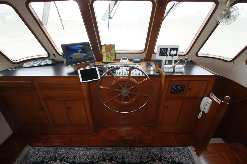 Noelani Yacht Photos Pics Pilothouse of 1982 DeFever 52 Offshore Cruiser with wooden wheel and navigation equipment.