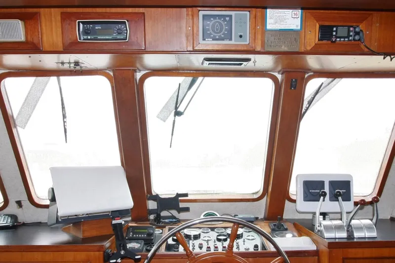 Noelani Yacht Photos Pics 1982 DeFever 52 Offshore Cruiser helm with wooden dashboard and navigation instruments.
