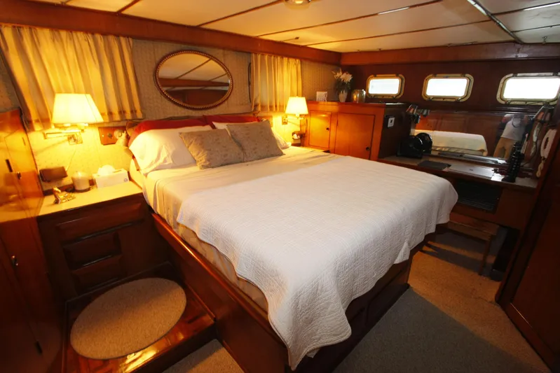 Noelani Yacht Photos Pics Luxurious cabin interior of 1982 DeFever 52 Offshore Cruiser with cozy bed and warm lighting.