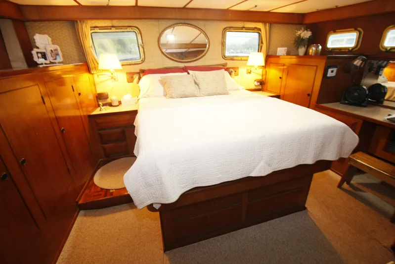 Noelani Yacht Photos Pics Luxurious 1982 DeFever 52 Offshore Cruiser bedroom with wood paneling and cozy decor.