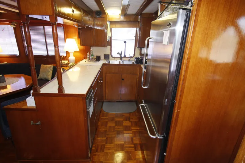 Noelani Yacht Photos Pics 1982 DeFever 52 Offshore Cruiser kitchen with wood cabinetry and stainless steel appliances.