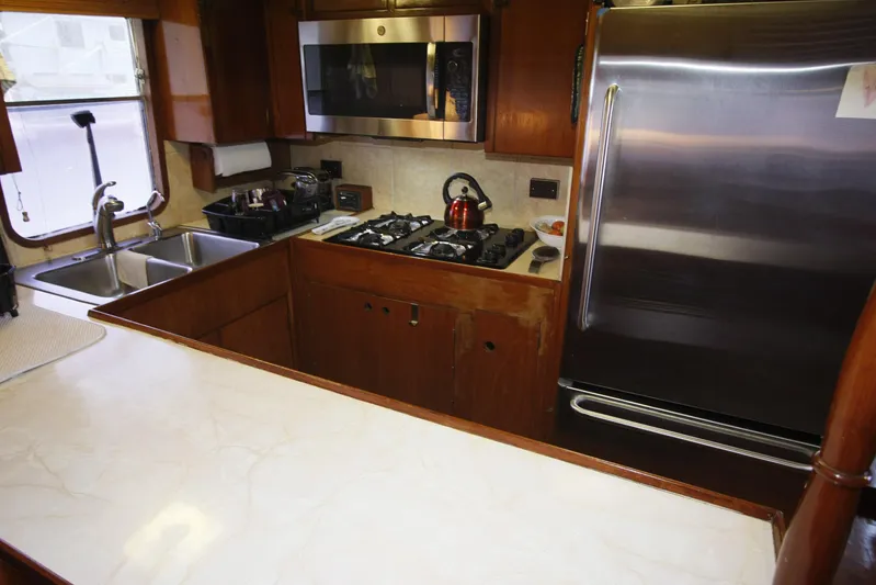 Noelani Yacht Photos Pics Galley kitchen in 1982 DeFever 52 Offshore Cruiser with stainless steel appliances.