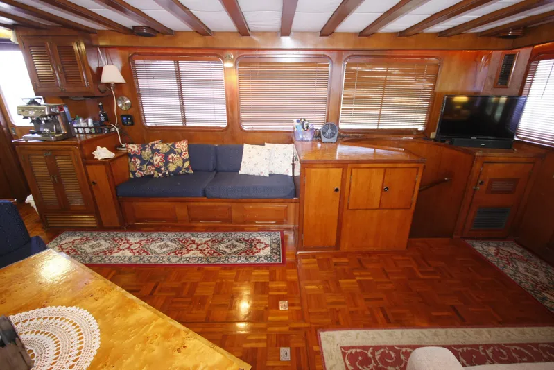 Noelani Yacht Photos Pics Interior of 1982 DeFever 52 Offshore Cruiser with wood paneling and cozy seating area.