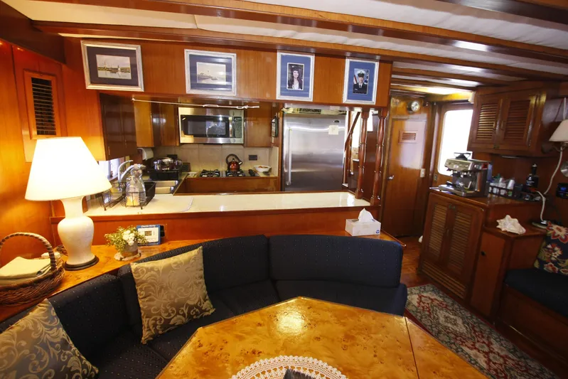 Noelani Yacht Photos Pics Interior of 1982 DeFever 52 Offshore Cruiser with cozy seating and kitchen area.